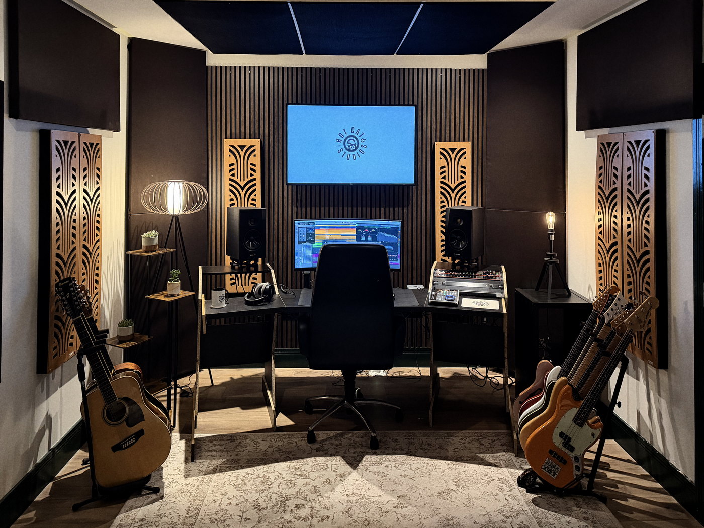 The Hot Cat Studios control room: mixing desk centred beneath the screen, monitors and house guitars either side.